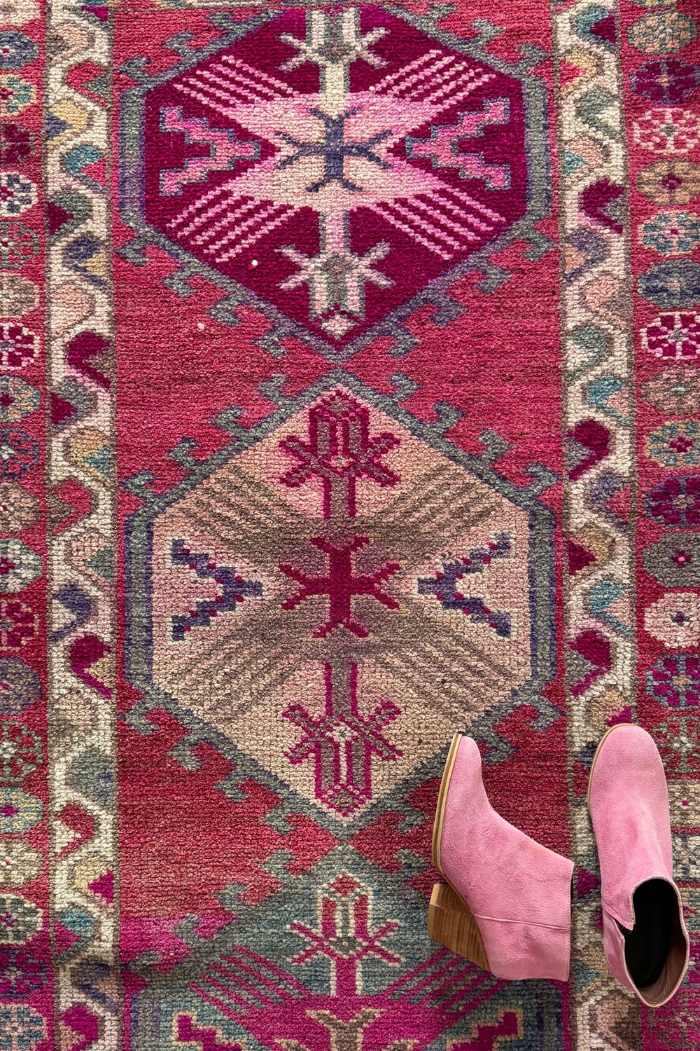 'Dutton' Vintage Turkish Runner - 2'11.5" x 13'5.5" - Canary Lane
Close up of a vintage handwoven Turkish runner showcasing an intricate medallion pattern. The design features rich, vibrant colors like red, pink, pink, purple, cream, and tan, with detailed floral borders.