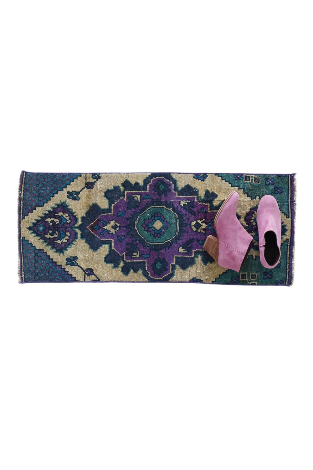 No. 1656 Mini Turkish Vintage Rug - 1'3.5" x 3'2" - Canary Lane
A hand woven rug with a bold geometric design, featuring a central medallion in purple and green tones, surrounded by  intricate teal and beige patterns. The rug's edges are neatly finished, and the overall style is a traditional or vintage aesthetic. This rug is the perfect size for a bathroom or entryway.