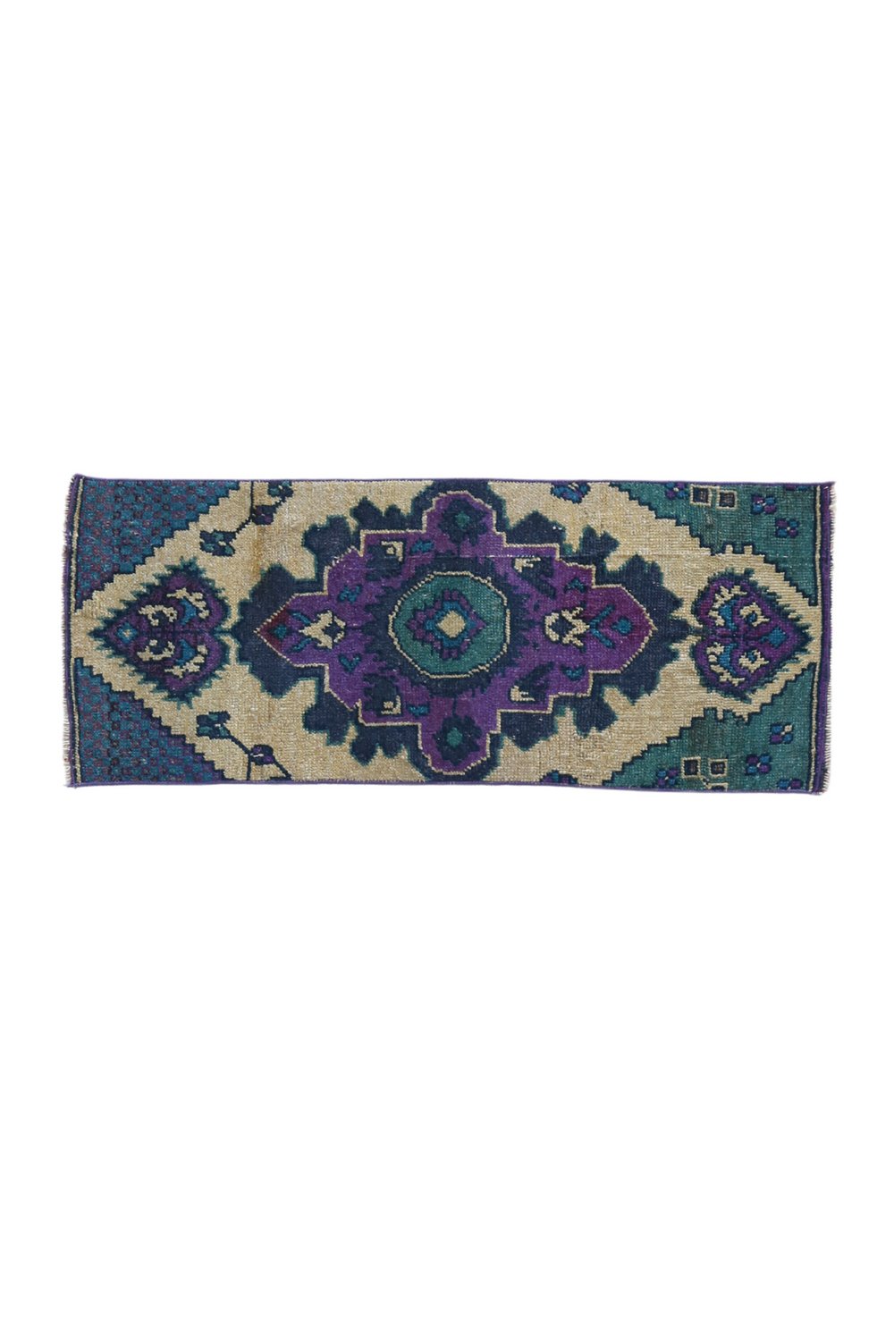 No. 1656 Mini Turkish Vintage Rug - 1'3.5" x 3'2" - Canary Lane
A hand woven rug with a bold geometric design, featuring a central medallion in purple and green tones, surrounded by  intricate teal and beige patterns. The rug's edges are neatly finished, and the overall style is a traditional or vintage aesthetic. This rug is the perfect size for a bathroom or entryway.